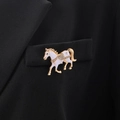 Dettaglio della lussuosa spilla a cavallo con smalto e strass su tasca di abito nero - Bianco