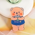 Cute orange acrylic bear badge pin featuring a baby shirt and drinking a green soda - 06 Milk Tea Bear
