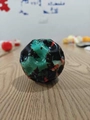 High bounce moon ball in black with vibrant green and orange splatter pattern detail - Camouflage 4-Color Black