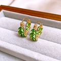 Gros plan de boucles d'oreilles émeraude vintage en or dans un écrin à bijoux en velours - 66# Boucle d'oreille épi de blé en forme de U en strass vert doré