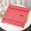 Faux cashmere pink scarf with tassels neatly displayed on a minimalist table - Watermelon Red