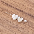 Macro shot of heart-shaped shell brooch with gold letter F and elegant pearl detail - Letter F