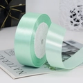 Mint green satin ribbon roll with a glossy finish for gift boxes and wedding favors - Green