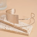 Detail of silver asymmetric choker with hammered metal texture on beige travertine stone - Silver Pleated Style / Silver