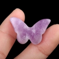 Polished amethyst crystal butterfly figurine with natural purple texture held by hand - Lilac Stone