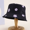 Kids black reversible bucket hat with purple smiling flower patterns on wood stand - 54cm (3-8 Years) / Black