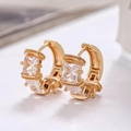 Macro shot of gold hoop earrings featuring square-cut micro-pave cubic zirconia stones - Gold