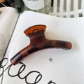 Amber tortoiseshell French hair claw clip placed on a minimalist magazine with soft lighting - 11.5cm / Matte Red Brown