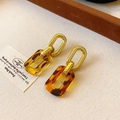Detail of vintage gold earrings with amber resin links on textured fabric - 33# Steel Pin Earrings - Gold - Ginger Amber Rectangle