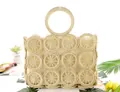 Detail of hollow woven paper rope beach bag with circular patterns and round handles - Beige