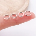 Set of four small silver jump rings for DIY jewelry making displayed on a fingertip - Double Layer-0.7x5mm / Bright Silver