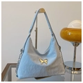 Detalle de bolso tote azul claro con adorno de mariposa dorada y textura arrugada chic - Azul