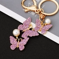 Pink crystal butterfly keychain with gold plating and decorative white pearls - Three Butterflies Purple