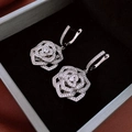 Detail view of silver camellia flower hoop earrings with zircon pavé in a velvet jewelry box - Hoop Earrings-Silver / Silver