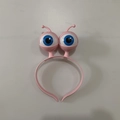 Detailed close-up of a pink LED alien headband featuring large cartoon glowing eyeballs - Light Pink