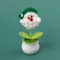 Detail van handgemaakte gehaakte kerstman plant met groene bladeren en een witte keramische pot - Groene Kerstmankop Potplant