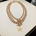 Detail of layered gold star pendant necklace with curb chains and dual T-bar toggle clasps - 4-Piece Gold Star Necklace Set / Gold