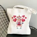 White canvas tote bag featuring a colorful cartoon unicorn and red heart print on a chair - Heart Unicorn (B902-5)