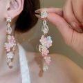 Gros plan de boucles d'oreilles à fleurs roses et cristaux portées par un mannequin - 26# Cristal à Longue Frange Rose (WE2593)