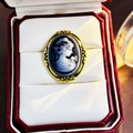 Vintage Victorian style black and white cameo brooch with a carved golden frame - Blue