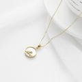 Golden shell necklace with LOVE script pendant for women on a white silk backdrop - Alphabet / Gold