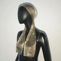 Detalle de turbante de lujo con pedrería, flecos largos y malla plateada en modelo - Dorado