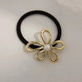Elastic hair tie in black featuring a gold metallic flower with a white pearl center - Pearl Flower Gold