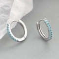 Silver huggie hoop earrings featuring micro-pave turquoise blue zircon stones - White Gold