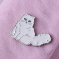 Detailed view of white enamel cat brooch pinned on pink knit fabric texture - Persian Cat