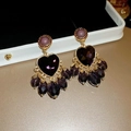 Macro shot of vintage baroque earrings with purple heart gemstone and beaded tassels - Gold-Purple-Baroque Heart