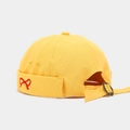 Detail of yellow canvas docker hat featuring red bow embroidery and adjustable metal buckle - Yellow