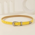 Cinturón fino de cuero amarillo con hebilla plateada sobre accesorios geométricos - Amarillo