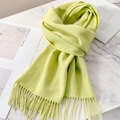 Soft pale green wool scarf featuring knit texture and fine tassel trim on a marble surface - Fruit Green