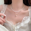 Close-up detail of an elegant 18k gold plated double layer pearl necklace on neck - Style 11