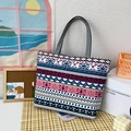 Canvas tote bag with colorful geometric patterns and gray handles on a table - White Ethnic Style