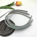 Three grey sequined glitter headbands with protective tips displayed on a coffee cup lid - Gray