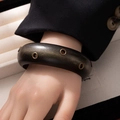 Detail view of a vintage wide wooden bangle featuring bronze eyelet metal decorations - Style L365-6 Black Air Hole