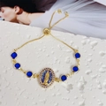 Detail of 18K gold-plated Virgin Mary bracelet with blue charms and purple zircons - Purple