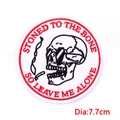 Detail view of a 7.7cm circular skeleton embroidery patch with red stitched text - Smoking Skull Style (PE6964CT)