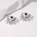 Pendientes de ojo de diablo en plata con piedra negra sobre fondo de piedra minimalista - Color Acero