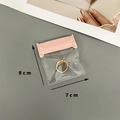 Transparent jewelry storage bag with pink slider, size 8x7cm, holding a gold ring - Transparent / 7*8cm