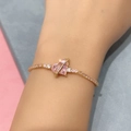 Close-up of gold bracelet featuring a pink heart zircon and sparkling floral accents - Saturn Heart - Gold