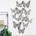 Vue détaillée de papillons décoratifs muraux argentés ajourés sur un mur blanc - Argenté