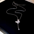 Macro shot of silver butterfly necklace with teardrop crystal on black velvet background - Butterfly Necklace - Silver