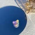 Gros plan sur une pince à cheveux ours en acétate avec dégradé violet et vert sur miroir - Tête d'Ours Colorée