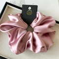 Flat lay of an oversized pink satin scrunchie with handmade tag on a linen jewelry tray - 18cm / Taro
