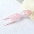 Detailopname van een doorschijnende roze U-vormige haarspeld op witte achtergrond - Lichtroze
