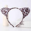 Detailed view of soft leopard print cat ears headband on a minimalist display - Leopard