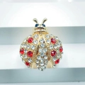 Detailed view of the red and clear rhinestones on the golden beetle brooch jewelry - Style 5-Gold Base Red Blue Stone Ladybug