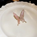 Vue détaillée du clip d'oreille papillon rose avec bords dorés sur plateau blanc - Ear Cuffs / Rose